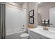 Bright bathroom featuring a shower-tub combo, white tiling, and modern sink at 510 Kenyon Dr, Denver, NC 28037
