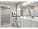 Well-lit bathroom featuring double vanity, white cabinetry, a walk-in shower, and a separate toilet area at 510 Kenyon Dr, Denver, NC 28037