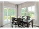 Elegant dining room with a modern table set, large windows overlooking the backyard, and stylish curtains at 510 Kenyon Dr, Denver, NC 28037