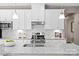 Close-up of kitchen showcasing granite countertops, stainless steel appliances, tile backsplash and white cabinetry at 510 Kenyon Dr, Denver, NC 28037