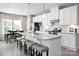Open-concept kitchen with a large island, stainless steel appliances, and bar stool seating, seamlessly connected to the dining area at 510 Kenyon Dr, Denver, NC 28037