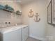 Well-organized laundry room with washer, dryer, and decorative anchors at 510 Kenyon Dr, Denver, NC 28037