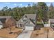 An aerial view showcases a charming two-story home with a lush treeline and a private backyard at 5813 Mcclintock Dr, Denver, NC 28037