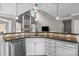 Open kitchen with white cabinetry, stainless steel dishwasher, and a breakfast bar overlooking living space at 5813 Mcclintock Dr, Denver, NC 28037