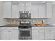 Close-up of a kitchen with stainless steel oven and microwave, and mosaic tile backsplash at 5813 Mcclintock Dr, Denver, NC 28037