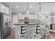 Modern kitchen with stainless steel appliances, center island with bar seating, and sleek white cabinetry at 5813 Mcclintock Dr, Denver, NC 28037