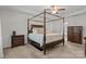 Spacious main bedroom featuring a four-poster bed, tray ceiling, and neutral decor at 5813 Mcclintock Dr, Denver, NC 28037