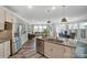 Open-concept kitchen flowing into the living room and dining area, featuring stainless steel appliances at 6282 Tea Olive Dr # Lot 236, Harrisburg, NC 28075