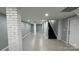 Finished basement featuring painted concrete floors, painted brick columns, stairs, and utility access at 702 E Grover St, Shelby, NC 28150
