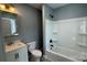 Bathroom featuring gray walls, framed mirror, vanity, toilet, and tub-shower combination at 702 E Grover St, Shelby, NC 28150