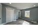 Bedroom featuring gray walls, trim detail, wood-look flooring, closet, and natural light from window at 702 E Grover St, Shelby, NC 28150