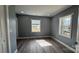 Bedroom featuring gray walls, trim detail, wood-look flooring, and natural light from windows at 702 E Grover St, Shelby, NC 28150