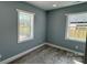 Bright bedroom featuring hardwood floors, two windows, and neutral gray paint at 702 E Grover St, Shelby, NC 28150