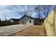 Exterior view of a single-story home featuring a newly installed fence and a concrete driveway at 702 E Grover St, Shelby, NC 28150