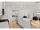 Open concept kitchen features white cabinets, stainless steel appliances, and a quartz island with seating at 758 Latrobe Dr, Iron Station, NC 28080