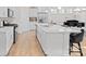 Open concept kitchen showcases a quartz island with seating, white cabinets, and stainless steel appliances at 758 Latrobe Dr, Iron Station, NC 28080