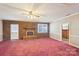 Spacious living room features a brick fireplace, ceiling fan, and natural light from large windows at 839 Oak Grove Rd, Kings Mountain, NC 28086