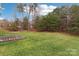 Large backyard with a wooded area and a wooden platform, perfect for outdoor activities and relaxation at 9391 Leyton Dr, Harrisburg, NC 28075