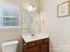 Well-lit bathroom featuring a vanity with a white countertop, a large mirror, and a framed picture at 9391 Leyton Dr, Harrisburg, NC 28075