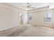 Spacious carpeted bedroom with a ceiling fan and three windows for natural light at 9391 Leyton Dr, Harrisburg, NC 28075