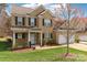 Charming two-story brick home with well-maintained landscaping, a front porch, and a two-car garage at 9391 Leyton Dr, Harrisburg, NC 28075