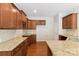 Kitchen featuring granite countertops, wooden cabinets and backsplash with a double sink at 9391 Leyton Dr, Harrisburg, NC 28075