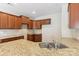 Close up on kitchen island featuring a double sink, granite countertops and dark cabinets at 9391 Leyton Dr, Harrisburg, NC 28075