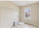 Bright laundry room with tile flooring and a window for natural light at 9391 Leyton Dr, Harrisburg, NC 28075