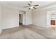 Large carpeted primary bedroom featuring ceiling fan and ensuite bathroom at 9391 Leyton Dr, Harrisburg, NC 28075