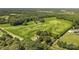 Lush aerial view of expansive green property with scattered trees, access roads and houses nestled amongst the greenery at Lot 14 Mayes Meadow Dr, Cornelius, NC 28078