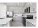 Kitchen features gray cabinets, stainless steel appliances, and a tiled backsplash at 112 Parker Claire Ln, Kings Mountain, NC 28086