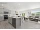 Open-concept kitchen featuring gray cabinets, a center island, and a seamless transition to the living area at 112 Parker Claire Ln, Kings Mountain, NC 28086