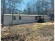 Manufactured home with a covered porch surrounded by a wooded landscape, offering privacy at 1151 Bowling Green Dr, Clover, SC 29710