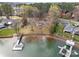 Aerial view showing lakefront property with a dock, well-kept lawn, and mature trees providing privacy at 116 Cottage Grove Ln, Mooresville, NC 28117