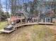 Aerial view of a home with a large deck, hot tub, dining area, and lush green yard at 116 Cottage Grove Ln, Mooresville, NC 28117