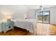Bright bedroom with wood floors, a lake view, and access to the balcony at 116 Cottage Grove Ln, Mooresville, NC 28117