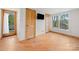 Bedroom with hardwood floors, wood doors, TV, and natural light from windows at 116 Cottage Grove Ln, Mooresville, NC 28117