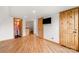 Bedroom featuring hardwood floors, wood doors, a TV, and access to a bathroom at 116 Cottage Grove Ln, Mooresville, NC 28117