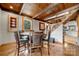 Cozy dining area boasts exposed wood beams, wood floors, a round dining table, and unique staircase at 116 Cottage Grove Ln, Mooresville, NC 28117