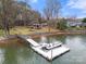 Wide view of a private boat dock on the water, and a well-maintained lawn leading to the house at 116 Cottage Grove Ln, Mooresville, NC 28117