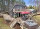 Aerial shot of a house featuring a large deck, an outdoor dining area, a hot tub and lush surroundings at 116 Cottage Grove Ln, Mooresville, NC 28117