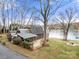Exterior angle showcasing a charming home with a large deck overlooking the lake at 116 Cottage Grove Ln, Mooresville, NC 28117