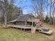 Exterior view of a multi-story home, large deck with hot tub, red umbrella and natural setting, with view of balcony at 116 Cottage Grove Ln, Mooresville, NC 28117