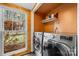 Convenient laundry room with modern washer and dryer, shelving, and a window with a yard view at 116 Cottage Grove Ln, Mooresville, NC 28117