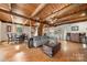Open living area with hardwood floors, exposed beams, sofa, and a dining table at 116 Cottage Grove Ln, Mooresville, NC 28117