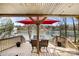 Covered outdoor dining area overlooking a lake with seating for four and lush foliage at 116 Cottage Grove Ln, Mooresville, NC 28117