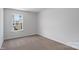 This bedroom has neutral walls and carpeting, white trim and a large window allowing for plenty of natural light at 1407 5Th Street Ne Dr, Hickory, NC 28601