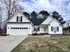 Charming white home featuring a two-car garage and well-maintained lawn at 145 Mcbride Dr, Rockwell, NC 28138