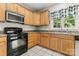 Kitchen showcasing black appliances, tiled flooring, wood cabinets, and a window with a view of the outdoors at 145 Mcbride Dr, Rockwell, NC 28138
