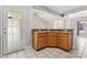 Kitchen area showcasing breakfast bar, wood cabinets, tile flooring, and a view into the living room with fireplace at 145 Mcbride Dr, Rockwell, NC 28138